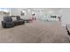 Basement showcasing open carpeted area with black leather reclining sofa and play area at 7410 S Old Hammer Way, Aurora, CO 80016