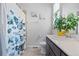 Bathroom view showcasing a commode, a large mirror, decorative art, and a stylish butterfly-themed shower curtain at 7410 S Old Hammer Way, Aurora, CO 80016