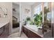Bathroom featuring a tub, plants, and lots of natural light coming from the window at 7410 S Old Hammer Way, Aurora, CO 80016