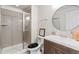 Well-lit bathroom featuring a tiled shower, wood vanity, a framed mirror, and neutral color scheme at 7410 S Old Hammer Way, Aurora, CO 80016
