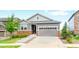 Charming gray two-story home with stone accents, a well-manicured lawn, and a two car garage at 7410 S Old Hammer Way, Aurora, CO 80016