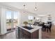 Bright, open kitchen boasts a center island, stainless steel appliances, and access to the outdoor deck at 7410 S Old Hammer Way, Aurora, CO 80016