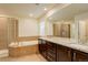 Bright bathroom featuring a soaking tub, shower, and double vanity with granite countertop at 13351 Olive Way, Thornton, CO 80602