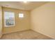 Empty bedroom featuring soft carpet, neutral walls, and sunlit windows at 13351 Olive Way, Thornton, CO 80602