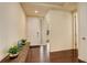 Bright entryway featuring hardwood floors, a white front door, and a wooden console table with decorative plants at 13351 Olive Way, Thornton, CO 80602