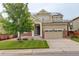 Charming two-story home with stone accents, solar panels, well-maintained lawn, and an attached two-car garage at 13351 Olive Way, Thornton, CO 80602