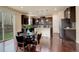 Modern kitchen with dark wood cabinets, granite countertops, stainless steel appliances, and a dining area with wood flooring at 13351 Olive Way, Thornton, CO 80602