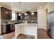 Stylish kitchen features granite countertops, stainless steel appliances, dark cabinets, and recessed lighting above a kitchen island at 13351 Olive Way, Thornton, CO 80602