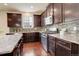 Well-equipped kitchen with granite countertops, stainless steel appliances, dark cabinetry, and hardwood flooring at 13351 Olive Way, Thornton, CO 80602