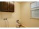 Functional laundry room with overhead cabinets and tiled floor at 13351 Olive Way, Thornton, CO 80602