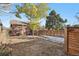 Fenced-in backyard with brick house and large trees at 601 Jackson St, Denver, CO 80206