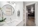 Bathroom with large round mirror over sink with views into hallway and shower at 601 Jackson St, Denver, CO 80206