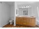 Bright bathroom with dual sinks, wood cabinetry, and a separate toilet area at 7440 S Blackhawk St # 104, Englewood, CO 80112