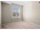 Cozy bedroom with neutral walls, plush carpet, and a bright window providing natural light at 7440 S Blackhawk St # 104, Englewood, CO 80112