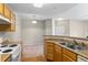 Kitchen area featuring wood cabinets, double sink, and a view into the carpeted living room at 7440 S Blackhawk St # 104, Englewood, CO 80112