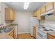 Functional kitchen with light wood cabinets, essential appliances, and durable countertops at 7440 S Blackhawk St # 104, Englewood, CO 80112