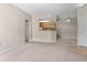 Open living room with neutral colors leading to the kitchen and dining area at 7440 S Blackhawk St # 104, Englewood, CO 80112