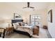 Comfortable bedroom featuring a ceiling fan, a large bed, and sliding glass doors to a balcony at 9557 Pearl Cir # 204, Parker, CO 80134