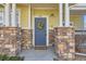 Close-up of front door with stone pillar accents and a decorative wreath at 9557 Pearl Cir # 204, Parker, CO 80134