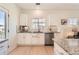 Well-lit kitchen with modern stainless steel dishwasher, granite countertops, and white cabinets at 9557 Pearl Cir # 204, Parker, CO 80134