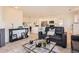 Open-concept living room connected to a stylish kitchen with white cabinetry and stainless appliances at 9557 Pearl Cir # 204, Parker, CO 80134