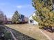 Spacious fenced backyard with grass and landscaping between two homes at 758 Poppywood Pl, Highlands Ranch, CO 80126