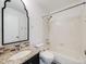 Well-lit bathroom featuring granite countertop, decorative mirror, and tiled shower and tub at 758 Poppywood Pl, Highlands Ranch, CO 80126