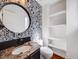 Stylish powder room with wallpaper and a round mirror at 758 Poppywood Pl, Highlands Ranch, CO 80126