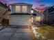 Charming two-story home featuring a gray exterior, brick accents, attached garage, and well-maintained lawn at 758 Poppywood Pl, Highlands Ranch, CO 80126