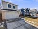 Charming two-story home featuring a gray exterior, brick accents, attached garage, and well-maintained lawn at 758 Poppywood Pl, Highlands Ranch, CO 80126