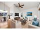 Bright living room with vaulted ceilings, hardwood floors, stylish furniture, and a view into the dining area at 758 Poppywood Pl, Highlands Ranch, CO 80126