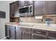 Close up showcasing kitchen with dark wood cabinets, granite countertops, and stainless steel microwave at 25525 E 1St Ave, Aurora, CO 80018