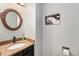 Half bathroom boasts granite countertops, decorative mirror, and updated fixtures at 8873 Yukon St, Broomfield, CO 80021