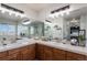 Bright bathroom with dual sinks, tile counters, and large mirrors with vanity lighting at 10144 Madison St, Thornton, CO 80229