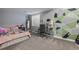 A quaint bedroom is designed with a decorative wall and includes a desk and window at 10144 Madison St, Thornton, CO 80229