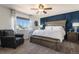 Main bedroom features a dark blue accent wall, chair, and large window at 10144 Madison St, Thornton, CO 80229