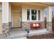 Charming front porch with stone accents, a bright yellow door, and a red bench with cheerful cushions at 787 Kendall Ct, Lakewood, CO 80214
