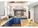 Well-appointed kitchen featuring granite countertops, blue cabinetry, and stainless steel appliances at 787 Kendall Ct, Lakewood, CO 80214