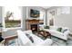 Cozy living room with a brick fireplace, white couches, and scenic views through large windows at 787 Kendall Ct, Lakewood, CO 80214