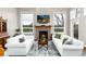Bright living room features a brick fireplace, large windows, and comfortable white sofas at 787 Kendall Ct, Lakewood, CO 80214