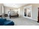 Spacious main bedroom with plush carpeting, a bench, and French doors leading to a private retreat at 787 Kendall Ct, Lakewood, CO 80214