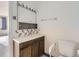 Bathroom featuring a vanity with wooden cabinets, decorated backsplash, mirror with lights, and white tiling at 625 S Alton Way # 3D, Denver, CO 80247