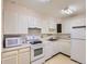 Galley kitchen featuring white appliances, ample cabinet space, and a double basin sink at 625 S Alton Way # 3D, Denver, CO 80247