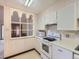 Galley kitchen featuring white appliances and a unique archway to an adjacent room at 625 S Alton Way # 3D, Denver, CO 80247