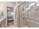 Bright bathroom with a glass enclosed shower, a neutral tile surround, and a view to the adjacent bedroom at 3963 N Quatar Ct, Aurora, CO 80019