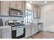 Well-equipped kitchen boasting stainless steel appliances, shaker cabinets, and tiled backsplash at 3963 N Quatar Ct, Aurora, CO 80019
