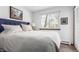 Cozy bedroom with a queen-size bed, soft white bedding, a blue headboard, and natural light at 4855 Edison Ave # 112, Boulder, CO 80301