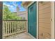 View of the balcony with a teal door, wood railing, and view of trees and nearby building at 8475 Pebble Creek Way # 204, Highlands Ranch, CO 80126