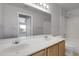 Bright bathroom featuring a double sink vanity, large mirror, and a shower-tub combination at 8475 Pebble Creek Way # 204, Highlands Ranch, CO 80126