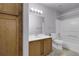 Bright bathroom with wood vanity, tile floors, and shower-tub combo at 8475 Pebble Creek Way # 204, Highlands Ranch, CO 80126
